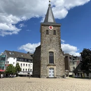 Alte Kirche in Velbert Alte Kirche in Velbert mit steilem Turm und Uhr, umgeben von modernen Gebäuden und blauem Himmel.