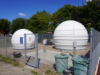 Volkssternwarte Langwedel Zwei weiße Kuppeln einer Sternwarte auf einem eingezäunten Gelände bei sonnigem Wetter.