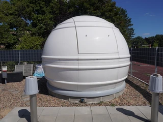 Volkssternwarte Langwedel Kuppelbau der Volkssternwarte Langwedel aus weißem Material, eingebettet in eine grüne Umgebung.