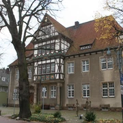 Altes Amtsgericht Petershagen Historisches Gebäude mit Fachwerkdetails, umgeben von Herbstbäumen, im Herzen von Petershagen.