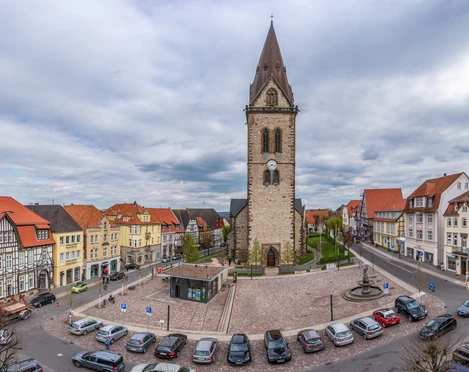 Neustädter Marktplatz (Ruben Emme) Neustädter Marktplatz mit beeindruckender Kirche im Zentrum, umgeben von historischen Fachwerkhäusern und parkenden Autos.