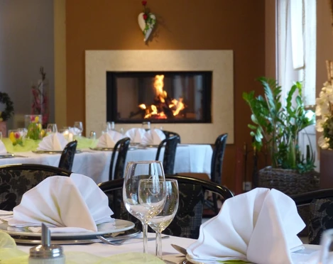 Saal im Haus der Gastlichkeit, Ratingen Ein stilvoll gedeckter Speisesaal mit elegant arrangierten Tischen und einem wärmenden Kamin.