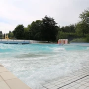 Panoramabad in Velbert Ein weitläufiges Freibad in Velbert mit türkisfarbenem Wasser und umliegendem Grün.