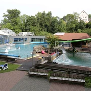 Parkbad in Velbert Ein Freibad mit zwei Pools und Sprungturm, umgeben von Bäumen und Liegestühlen in Velbert.