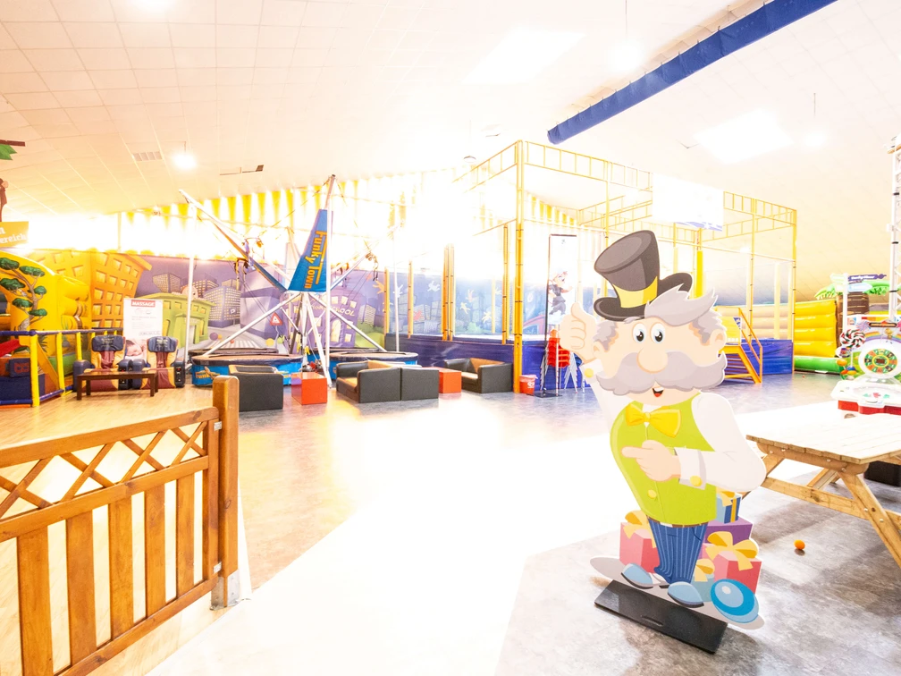 Funky Town in Ratingen Ein Indoor-Spielplatz mit bunten Klettergerüsten und einer lebensgroßen Figur eines älteren Mannes.