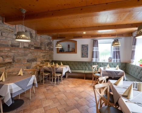 Da Giovanni Farchant - Innenbereich  Gemütlich eingerichtete Stube mit großer Eckbank ringsherum und gedeckten Tischen