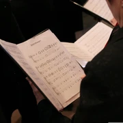 Chorkonzert Ein Chorsänger liest Notenblätter während einer Probe bei einem Chorkonzert.