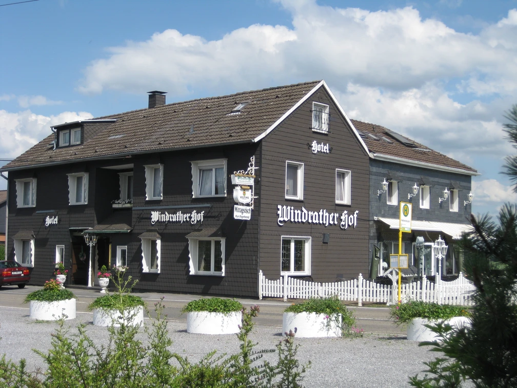 Hotel-Restaurant Windrather Hof in Velbert Ein traditionelles Fachwerkgebäude mit weißen Fensterrahmen und detaillierten Holzarbeiten.