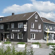 Hotel-Restaurant Windrather Hof in Velbert Ein traditionelles Fachwerkgebäude mit weißen Fensterrahmen und detaillierten Holzarbeiten.