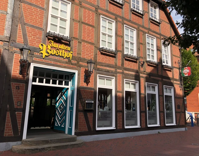 Alter Posthof Das Foto zeigt die Fassade eines historischen Fachwerkhauses mit der Aufschrift „Im alten Posthof“.