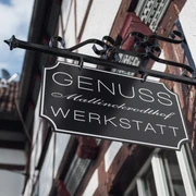 Genusswerkstatt exterior Schild der "Genusswerkstatt Mallinckrodthof", angebracht an einer Fachwerkfassade, zeigt den Namen.
