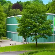 Außenansicht Neanderthal Museum in Mettmann Neanderthal Museum in Mettmann, moderne Glasarchitektur, umgeben von üppigem Grün und einem Spazierweg.