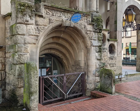 WunstorfInfo01 (1).jpg Eingang der Stadtwerke Wunstorf mit historischem Rundbogen aus Sandstein und blauen Hinweisschild.