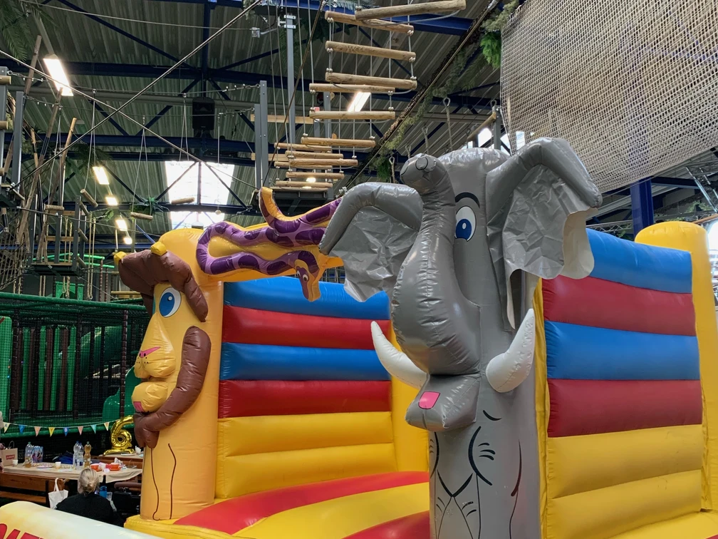 Hüpfburg im Okidoki Kinderland in Langenfeld Hüpfburg mit bunten Elementen und Tiermotiven, darunter ein Elefant und eine Giraffe, im Indoor-Spielbereich.