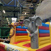 Hüpfburg im Okidoki Kinderland in Langenfeld Hüpfburg mit bunten Elementen und Tiermotiven, darunter ein Elefant und eine Giraffe, im Indoor-Spielbereich.