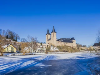 Schloss Rochlitz im Winter - Schlösser der Leipzig Region Gesamtansicht des Schloss Rochlitz bei Schnee mit der zugefrorenen Mulde im Vordergrund, Mulderadweg, Lutherweg Sachsen