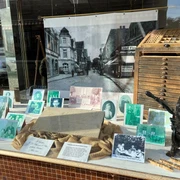 IG Synagoge Hoya Eine Schaufensterpräsentation zeigt historische Fotografien und Druckwerkzeuge, die an eine Druckerei erinnern.