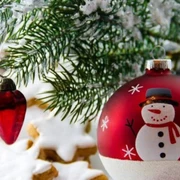 Weihnachtskugel.jpg Rot-weiße Weihnachtskugel mit Schneemann, hängend an Tanne, daneben rote Herzornamente und Kekse.