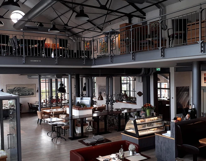 Gastraum Eisenhütte Gastraum eines gemütlichen Restaurants mit industriellem Flair: Galerieebene, Sitzbereiche und viel Tageslicht.