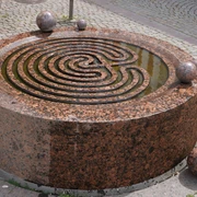 Der Gezeitenbrunnen in Verden ist ein runder, spiralförmiger Brunnen aus rötlichem Granit mit Kugeln.