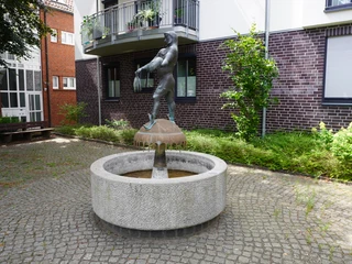 Störtebeker-Brunnen Störtebeker-Brunnen in einem Innenhof, zeigt eine Bronzestatue mit erhobenem Krug auf steinernem Brunnen.