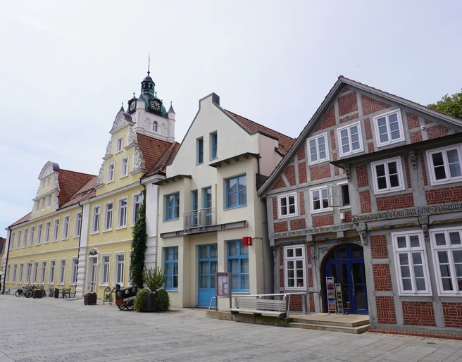 Tourist-Info Verden Eine historische Häuserzeile in Verden präsentiert farbenfrohe Fassaden und traditionelle Architektur.