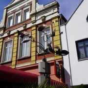 Wachstumssäule Moderne Kunstinstallation "Wachstumssäule" vor historischem Gebäude mit markanten Fenstern und Geländer.