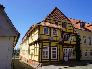 Bürgerhaus 1561 Fachwerkhaus von 1561 mit dekorativen Holzdetails und roten Ziegeln, unter blauem Himmel.