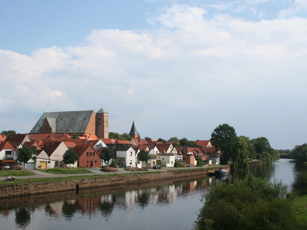 Reiterstadt Verden Verden mit historischer Architektur entlang der Aller, eingerahmt von üppigem Grün und sanftem Fluss.