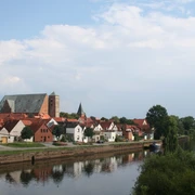 Reiterstadt Verden Verden mit historischer Architektur entlang der Aller, eingerahmt von üppigem Grün und sanftem Fluss.