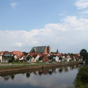 Reiterstadt Verden Blick auf Verden mit der gotischen Domkirche, umgeben von kleinen Häusern am Ufer der Aller.