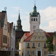Rathaus Verden Historisches Rathaus von Verden mit weißem Turm und Uhr, umgeben von Fachwerkhäusern und Bäumen.