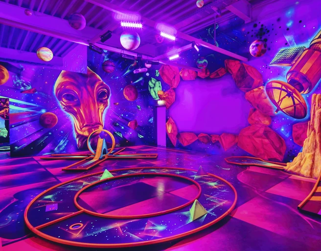 Blacklight_District_foto_ccbysa_foto©adventure-district.jpeg Im Blacklight District in Bispingen leuchten Planeten und futuristische Designs in Neonfarben an der Wand. Eine intergalaktische Atmosphäre lädt dazu ein, kreativ zu werden.