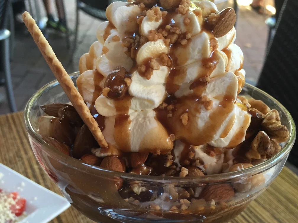 Eisbecher Nuss Ein Eisbecher mit Sahne, knackigen Nüssen, knuspriger Waffelrolle und süßem Karamellsirup.