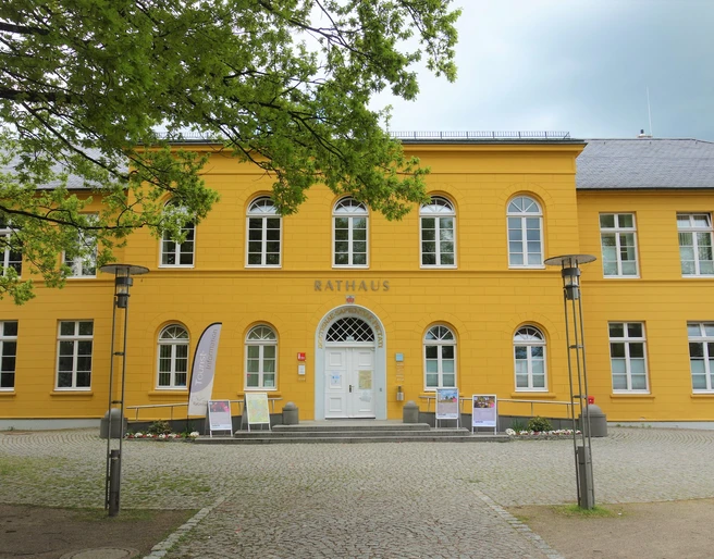 Rathaus Das Rathaus in Ratzeburg ist ein gelbes Gebäude mit weißen Fenstern und Tür. Davor ist ein Platz mit Gehwegen