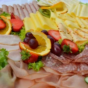 Fruehstueck_SHS_CC-BY-SA_Teutoburger_Wald_Stadt_Schloss_Holte-Stukenbrock (3).jpg Vielfältige Frühstücksplatte mit Aufschnitt, Käse, frischen Erdbeeren, Orangenscheiben und Trauben.