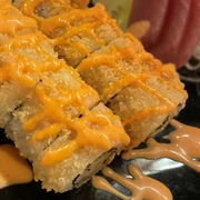 Sushi Tempura_CCBYSA_Teutoburger Wald_Stadt Schloss Holte-Stukenbrock-10.jpg Sushi-Tempura-Gericht auf schwarzem Teller mit knusprigem Teig und würziger Soße garniert.