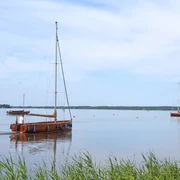 Steinhuder Meer Ruhiges Gewässer mit Segelbooten und weitläufigem Horizont am Steinhuder Meer unter blauem Himmel.