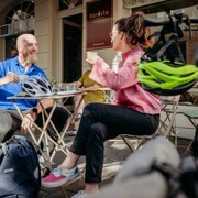 Zwei Personen genießen bei Sonnenschein Getränke an einem Außentisch des Café Barösta in Osnabrück.