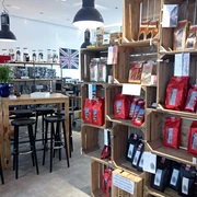 Eine helle Kaffeeverkaufsstelle mit Regalen voller Kaffeetüten und einer ansprechenden Einrichtung.