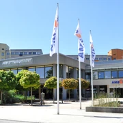 AMEOS_Eingang (©AMEOS Einrichtungen Ratzeburg).jpg Die Senioreneinrichtung von außen. Vor dem Eingang stehen Bäume und gehisste Fahnen mit der Aufschrift AMEOS