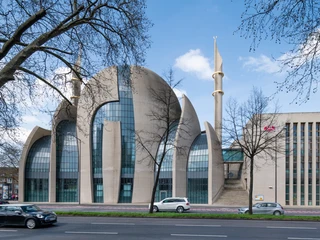 Central Mosque Cologne Das Bild zeigt die moderne Kuppel und Minarette der Kölner Zentralmoschee bei blauem Himmel.The picture shows the modern dome and minarets of Cologne's central mosque under a blue sky.