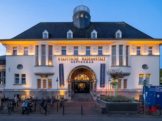 Neptunbad Historische Fassade des Neptunbads in Köln, beleuchtet bei Dämmerung.Historic facade of the Neptunbad in Cologne, illuminated at dusk.