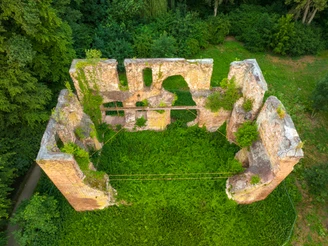 Rahden-Museumshof-Teutoburger-Wald-Tourismus-D-Ketz-007-CC-BY-SA.jpg Luftaufnahme einer überwucherten, rechteckigen Burgruine mit teils erhaltenen, fensterlosen Mauern.