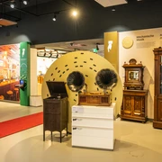 Espelkamp-Schloss Benkhausen-Automatenmuseum-Teutoburger-Wald-Tourismus-D-Ketz-076-CC-BY-SA.jpg Ein Ausstellungsraum mit antiken mechanischen Musikgeräten, darunter Grammophone und Musiktruhen.