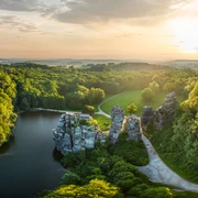 Horn-Bad Meinberg-Externsteine-Teutoburger-Wald-Tourismus-D-Ketz-002.jpg Luftaufnahme von den mystischen Externsteinen inmitten eines üppigen Waldes im Sonnenuntergang.