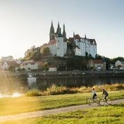 Fahrrad fahren in Meißen.jpg Fahrradfahrer auf dem Elberadweg, im Hintergrund die Albrechtsburg Meissen