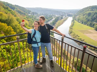 Beverungen-Weser Skywalk-Teutoburger-Wald-Tourismus-D-Ketz-020.jpg <p>Paar auf Aussichtsplattform fotografiert sich vor grünem Tal, Fluss und bewaldeten Hügeln.</p><p>Paar op uitkijkplatform gefotografeerd voor groene vallei, rivier en beboste heuvels.</p> <p<p>Couple on viewing platform photographed in front of green valley, river and wooded hills.</p> <p