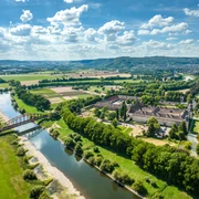 Hoexter-Corvey-Teutoburger-Wald-Tourismus-D-Ketz-061.jpg Luftaufnahme des Wesergebiets mit einem Schloss, umgeben von Wiesen, Bäumen und einem Fluss.