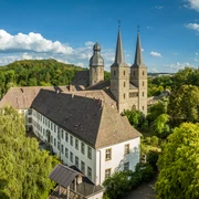 Marienmuenster-Abtei Marienmuenster-Teutoburger-Wald-Tourismus-D-Ketz-097.jpg Luftaufnahme der Abtei Bursfelde mit zwei markanten Türmen, umgeben von üppiger grüner Natur.